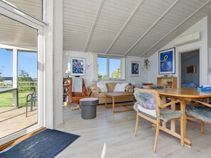 A spacious living area with a large window, a sofa, a dining table, and a chair. - "Sighrik" - 600m from the sea by Interhome (Stubbekøbing)