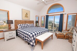 A bedroom with a large bed, a bedside table, a lamp, a chair, and a dresser. - Semi-Oceanfront- Private Pool, Hot Tub-OH1200, Spyglass (Corolla)
