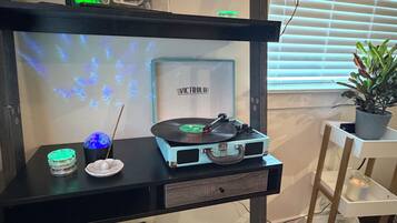 A room with a black desk featuring a turntable, incense, and a decorative globe.