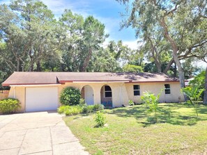 A single-story house with a garage, a front porch, and a small front yard. - Fall Escape at Spanish Style 4br/3ba home! (Niceville)