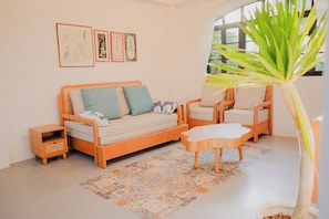 A cozy living room with a sofa, armchairs, a coffee table, and a patterned rug.
