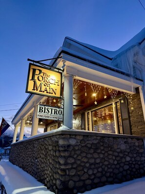 A bistro with a stone facade and a sign that reads 'The Porch on Main.' - Rev and Ride Trailside Retreat: Direct ATV & Snowmobile Access: Sleeps 9 (Colebrook)