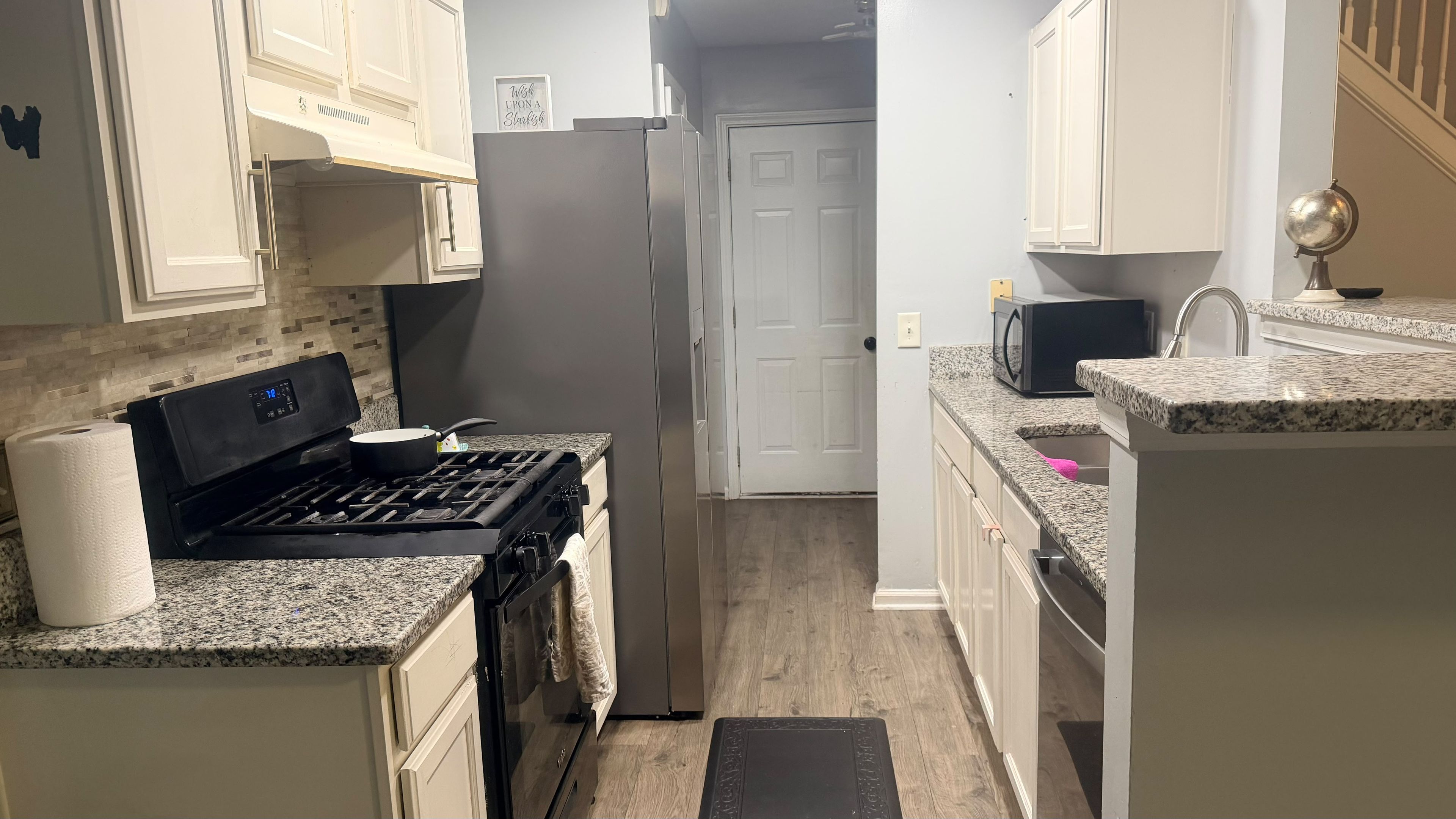 A kitchen with a stove, microwave, and cabinets.