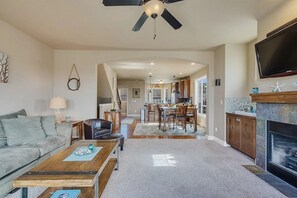 Ein großzügiges Wohnzimmer mit Kamin, Essbereich und einer Küche im Hintergrund.
