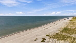 Ein Strand mit blauem Himmel und ruhiger See.