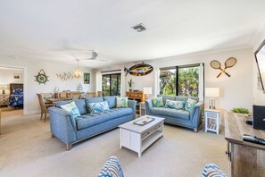 Ein Wohnzimmer mit zwei Sofas, einem Couchtisch und einer TV-Konsole.
