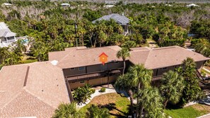 A multi-story building with a flat roof, surrounded by palm trees and other vegetation. - Blind Pass Condos at Bowman's Beach A205 on beautiful Sanibel Island (Sanibel)