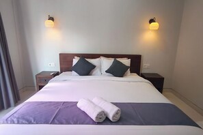 Ein Hotelzimmer mit einem Bett, zwei Nachttischen und zwei Wandleuchten.