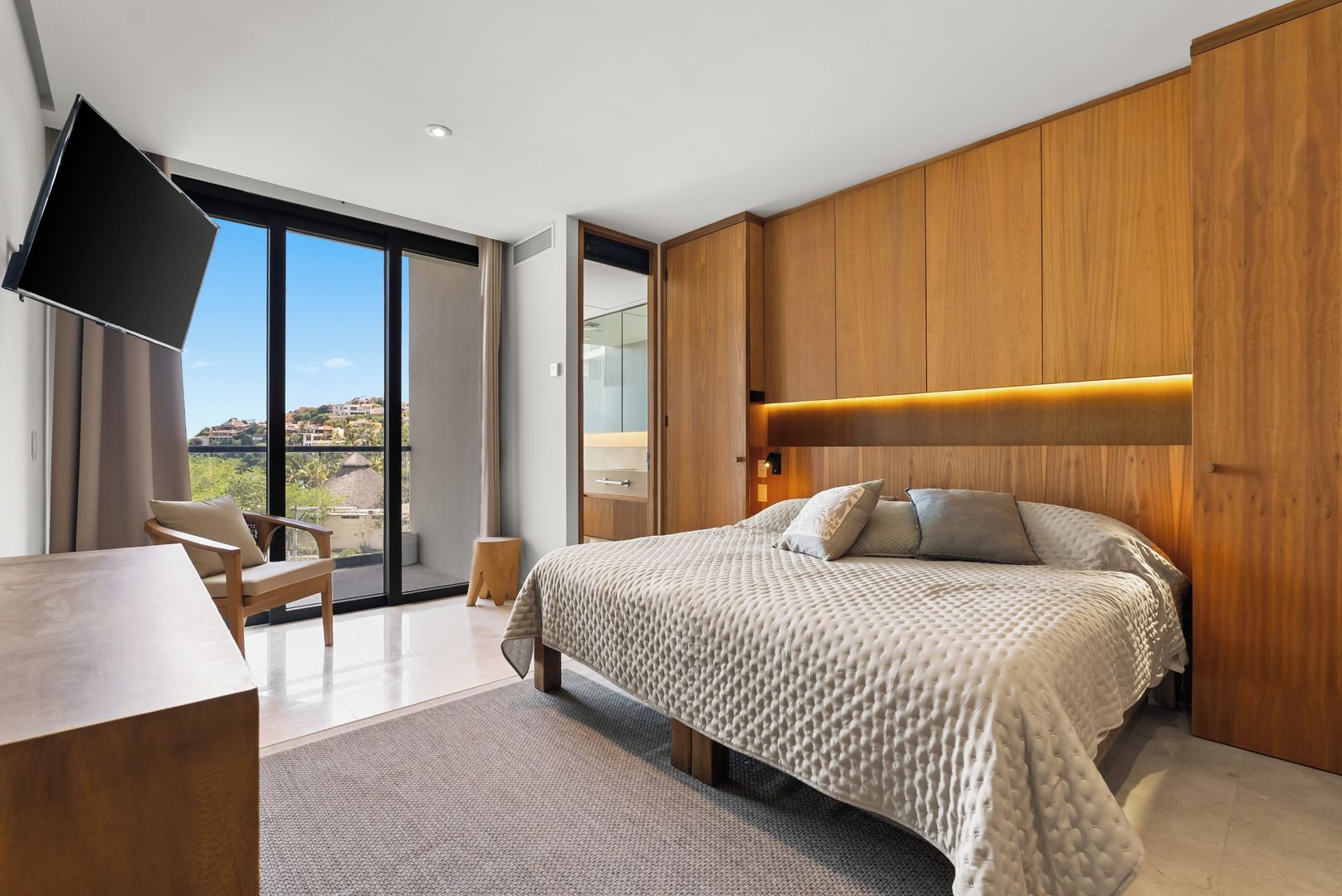 Een moderne slaapkamer met een groot bed, een bureau en een televisie.