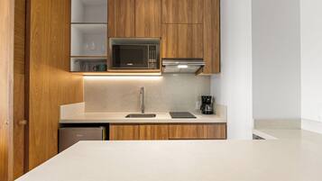 Une cuisine moderne dotée de meubles en bois, d’un four à micro-ondes, d’une machine à café et d’un lave-vaisselle.