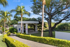 A modern outdoor pavilion with seating, surrounded by well-maintained hedges and palm trees. - Relaxing Getaway with Panoramic Views (Bucerías)