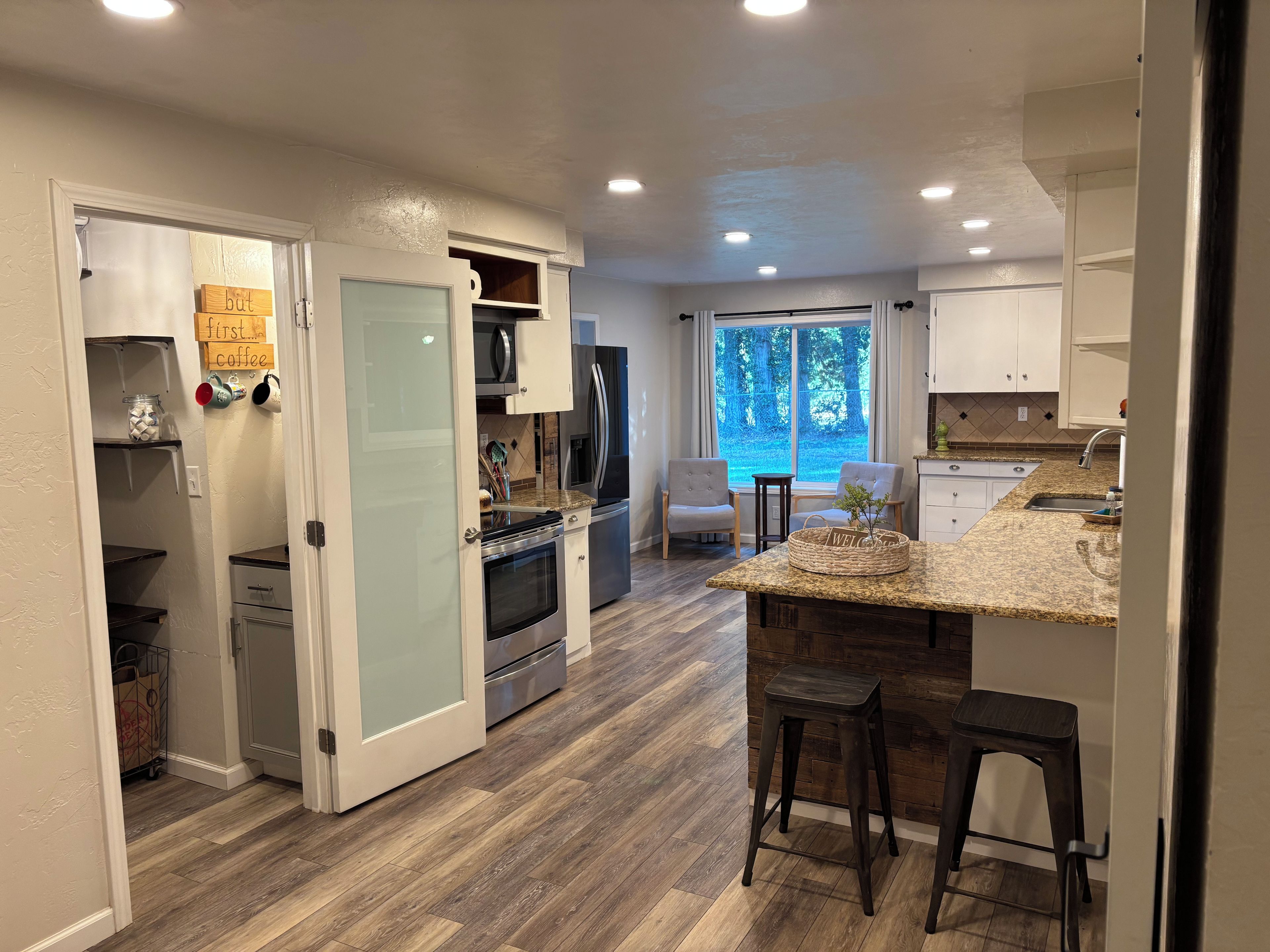 A modern kitchen with a central island, built-in appliances, and a view to the outdoors.