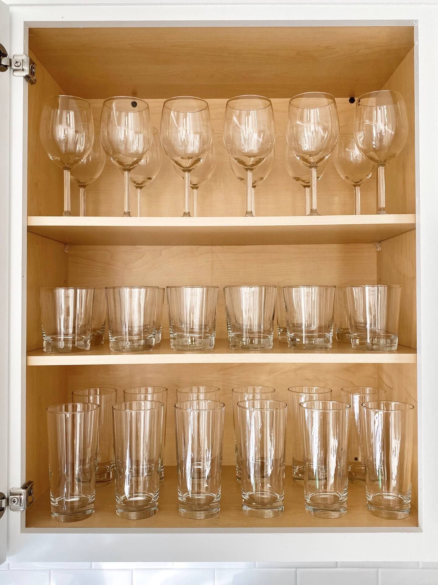Un meuble avec plusieurs étagères contenant divers objets en verre.