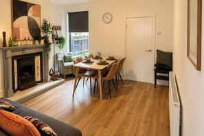Ein Wohnzimmer mit Kamin, Esstisch und einer Couch.