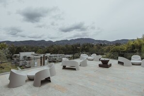 Eine Dachterrasse mit moderner Sitzgelegenheit und Blick auf Berge.
