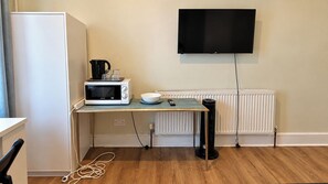 A compact kitchenette with a microwave, kettle, and a small table. - East London Studio, Sleeps 2 with WiFi (London)