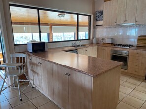 A kitchen with a large island, a microwave, a sink, and a stove.