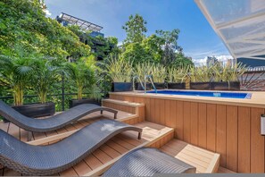 Eine Dachterrasse mit Pool, Liegestühlen und Pflanzen.