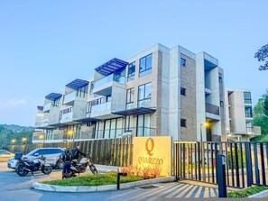 A modern multi-story building with a prominent entrance and a sign reading 'QUARZZO'. - Modern Loft El Retiro Balcony Quiet (Retiro)