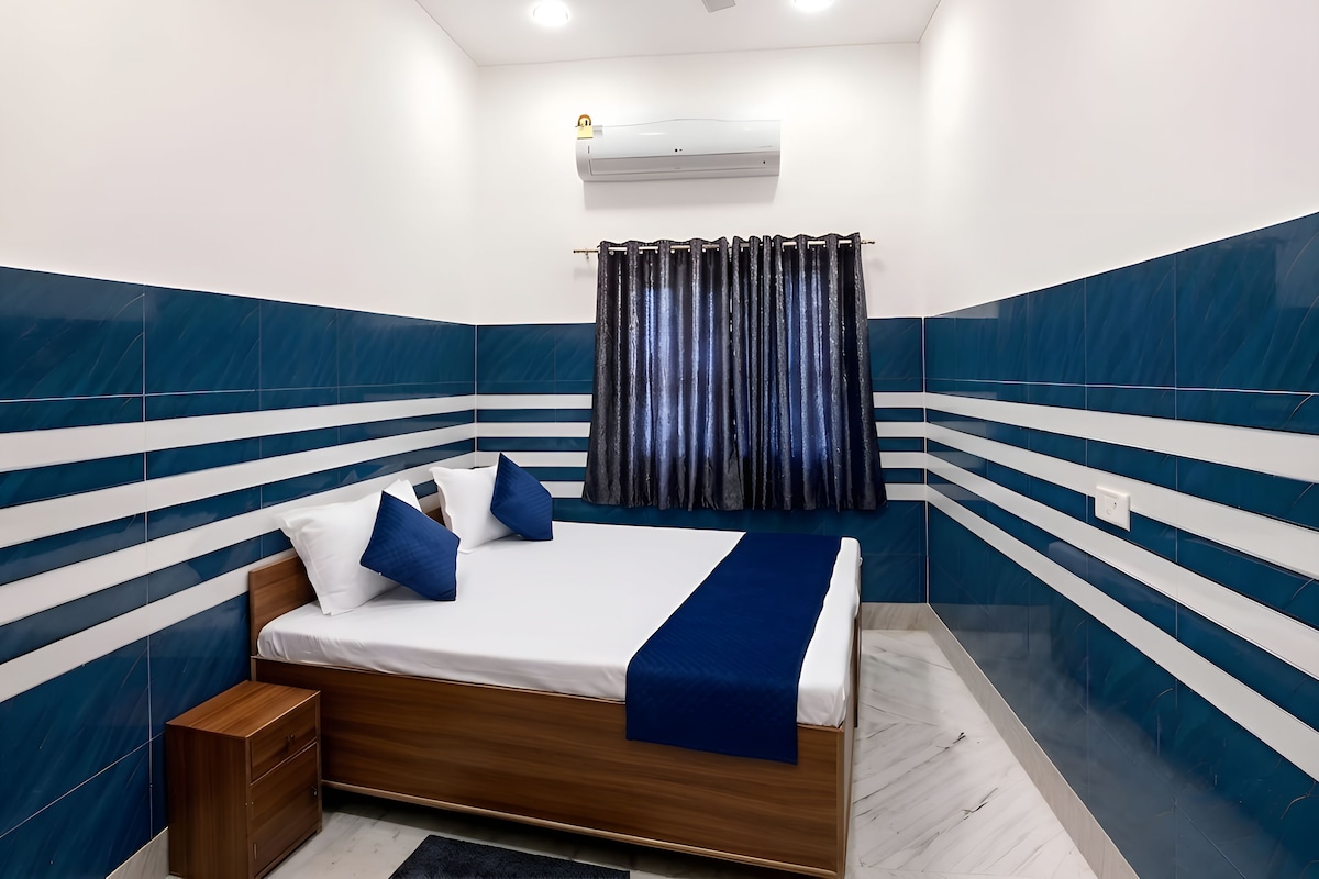 A bedroom with a bed, a nightstand, a ceiling fan, and an air conditioning unit.