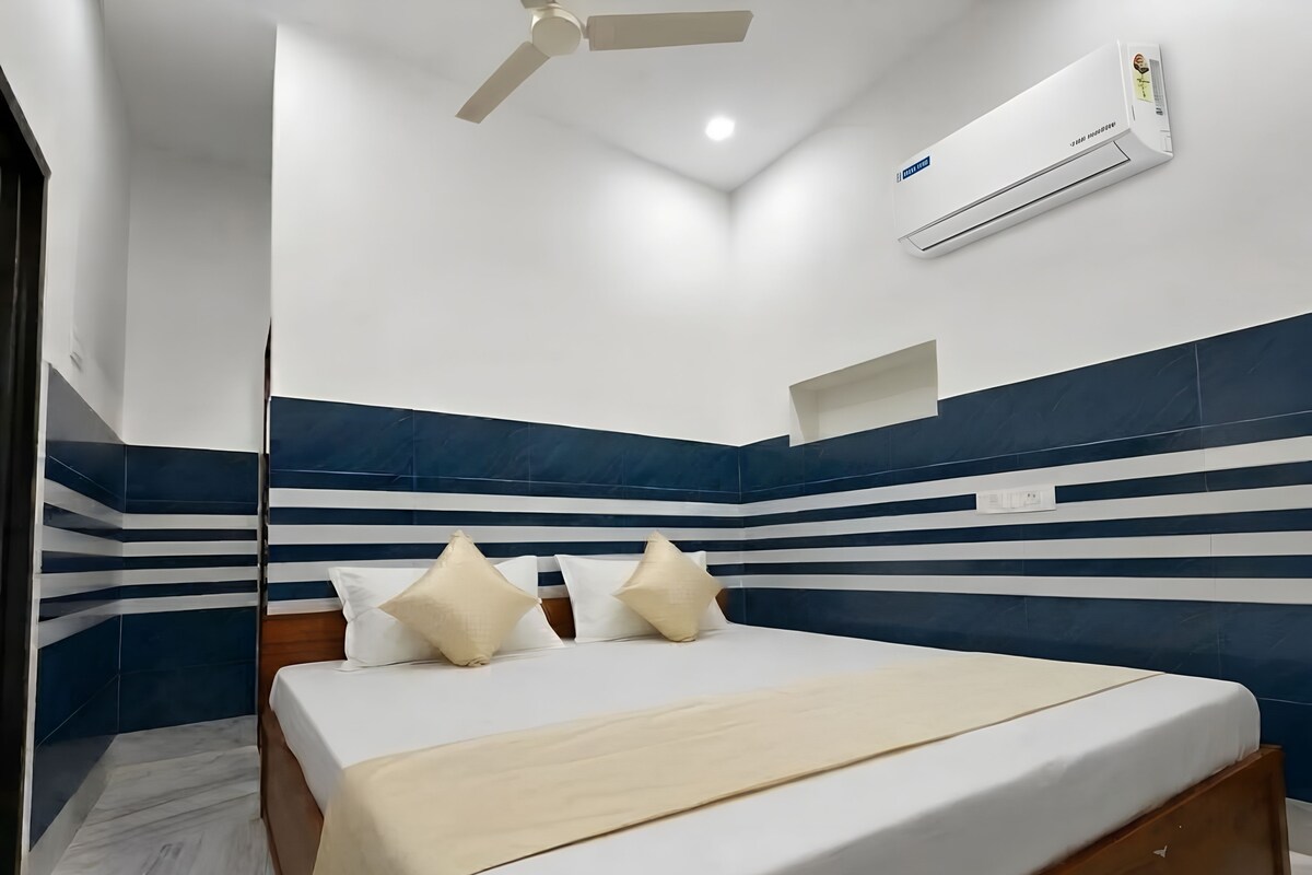 A modern bedroom with a bed, a ceiling fan, and an air conditioning unit.