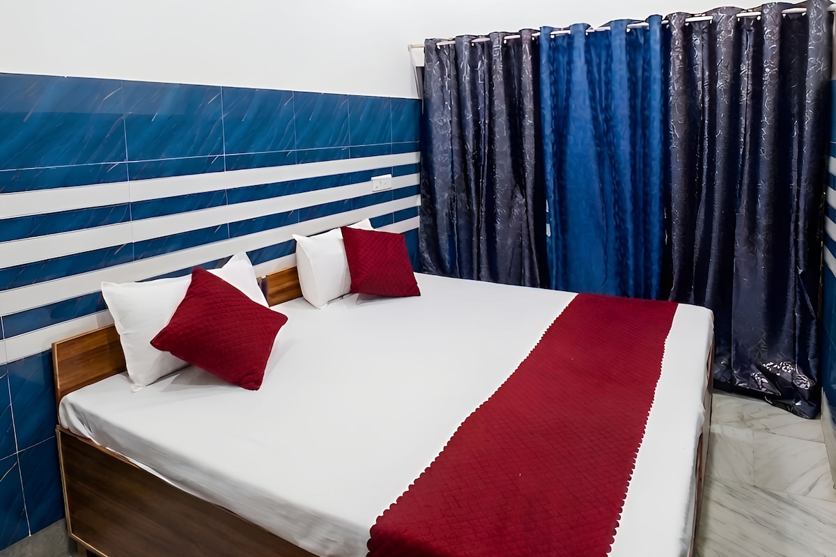 A bedroom with a bed, a ceiling fan, and curtains.