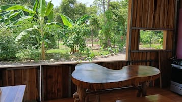 Un banc en bois dans une pièce donnant sur un jardin.