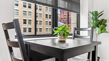 A dining area with a table, chairs, and a potted plant.