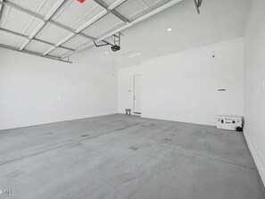 A spacious indoor area with a high ceiling, a door, and a white box on the floor. - Fantastic 4-bedroom house with AC in sunny Phoenix (Phoenix)