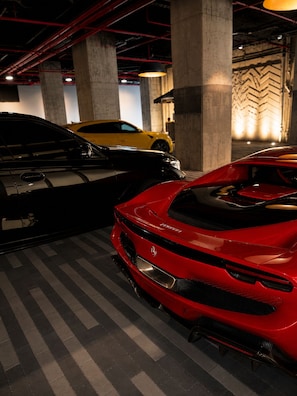 A parking garage with three sports cars parked in a row. - E11EVEN Executive Penthouse  Luxury Hotel-Style Retreat (Miami)