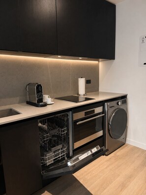 A compact kitchen with a dishwasher, oven, and a coffee machine. - E11EVEN Executive Penthouse  Luxury Hotel-Style Retreat (Miami)