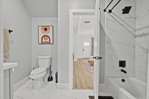 Een moderne badkamer met toilet, wastafel en douche.
