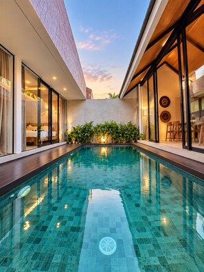 A modern hotel with a swimming pool, large windows, and a view of the sky. - Villa Jia by Kelle, Ubud (Gianyar)
