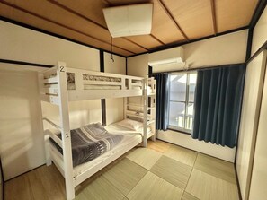 A bunk bed room with a window, curtains, and an air conditioning unit. - Beginning House - Authentic Japanese-Style Renovated Accommodation, Direct Access to the Airport + Disney Bus (葛飾区青戸)