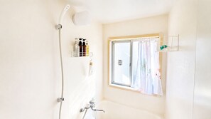 A bathroom with a shower, a window with a curtain, and toiletries on a shelf. - Beginning House - Authentic Japanese-Style Renovated Accommodation, Direct Access to the Airport + Disney Bus (葛飾区青戸)