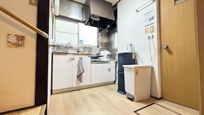 A compact kitchen with a refrigerator, stove, and sink. - Beginning House - Authentic Japanese-Style Renovated Accommodation, Direct Access to the Airport + Disney Bus (葛飾区青戸)