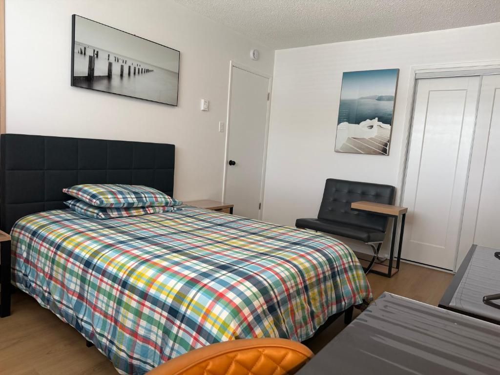 A bedroom with a bed, a desk, and a chair. There are two doors, one leading to a bathroom and another to a closet.