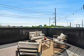 A rooftop terrace with a sofa set, a coffee table, and a decorative vase. - Modern Condo-5 Min to Broadway -Walk to Coffee (Nashville)