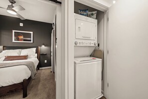 A compact bedroom with a bed, a nightstand, a lamp, and a ceiling fan. - Modern Condo-5 Min to Broadway -Walk to Coffee (Nashville)