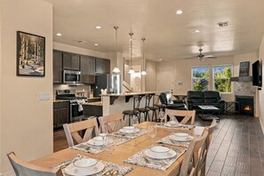 A modern kitchen with dark cabinets, stainless steel appliances, and pendant lighting. - Respite in the Pines | San Francisco Peaks Views | 3BR (Flagstaff)