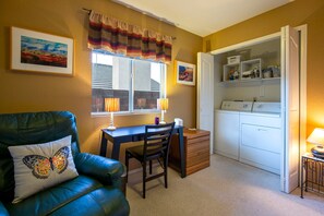 A room with a desk, chair, and a closet containing a washer and dryer. - Starr Pass Vista | Golf Community | Mountain Views | 3BR (Tucson)