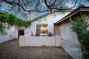 A patio area with a seating arrangement, a window, and a door. - Starr Pass Vista | Golf Community | Mountain Views | 3BR (Tucson)