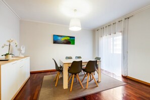 Ein Essbereich mit Tisch, Stühlen, einem Ventilator und einem Gemälde an der Wand.