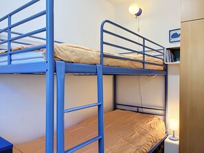 Ein Stockbett mit einer Leiter, einer Nachttischlampe und einer Wandleuchte.