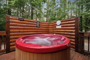 Ein Whirlpool, umgeben von Holzbalken, mit Temperaturanzeige und einem Schild, das einen Entspannungsbereich kennzeichnet.