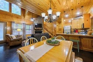 Ein Interieur einer Holzhütte mit Essbereich, Küche und Wohnzimmer.