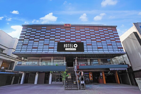 A hotel with a modern facade, a prominent sign, and a staircase leading to the entrance.