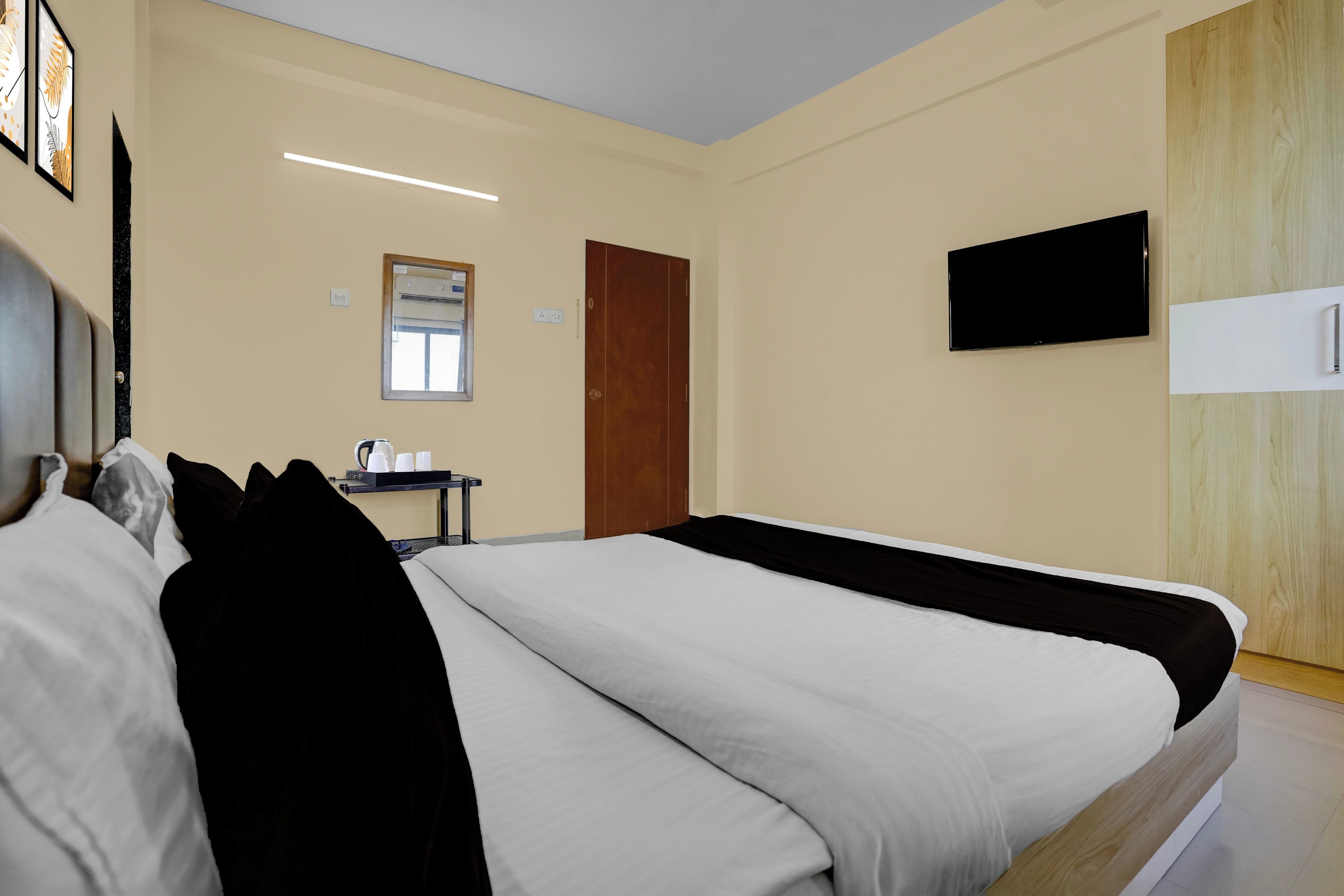 A hotel room with a bed, a desk with a chair, a television, and a window.