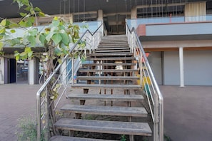 A staircase with metal railings leading to an upper level of a building. - Hotel O Vapi GIDC Formerly Zion Inn (Vapi)