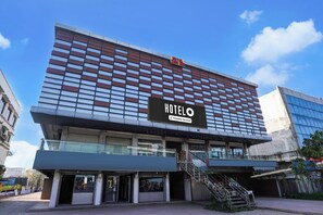 A hotel with a modern facade, a prominent sign, and a staircase leading to the entrance.
